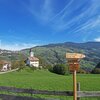 Signpost on the path near Tagusa. On the background, the village of Lajen/Laion on the opposite part of the valley. Foto: AT, &copy; Peer